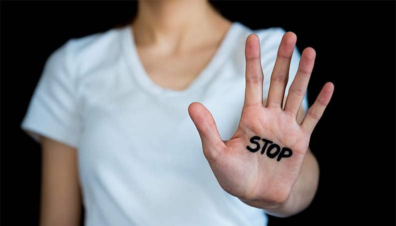 Hand met STOP erop geschreven met zwarte letters