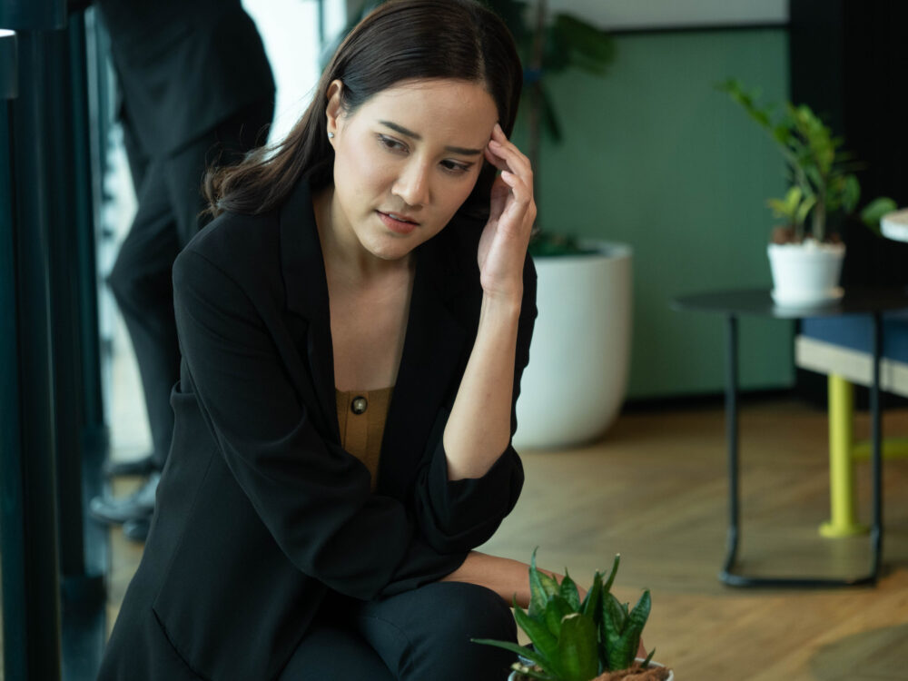 Vrouw met stress die met haar handen aan haar voorhoofd zit